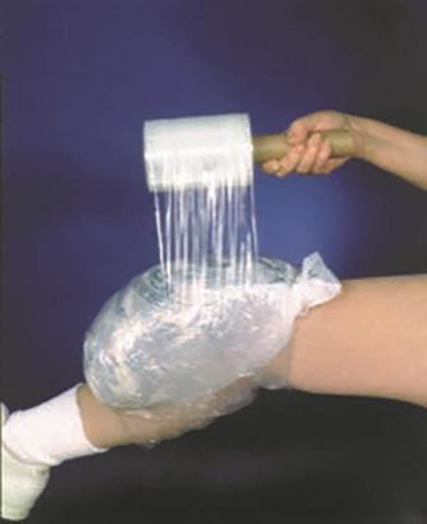 Isolated leg with ice bag on knee being self-wrapped